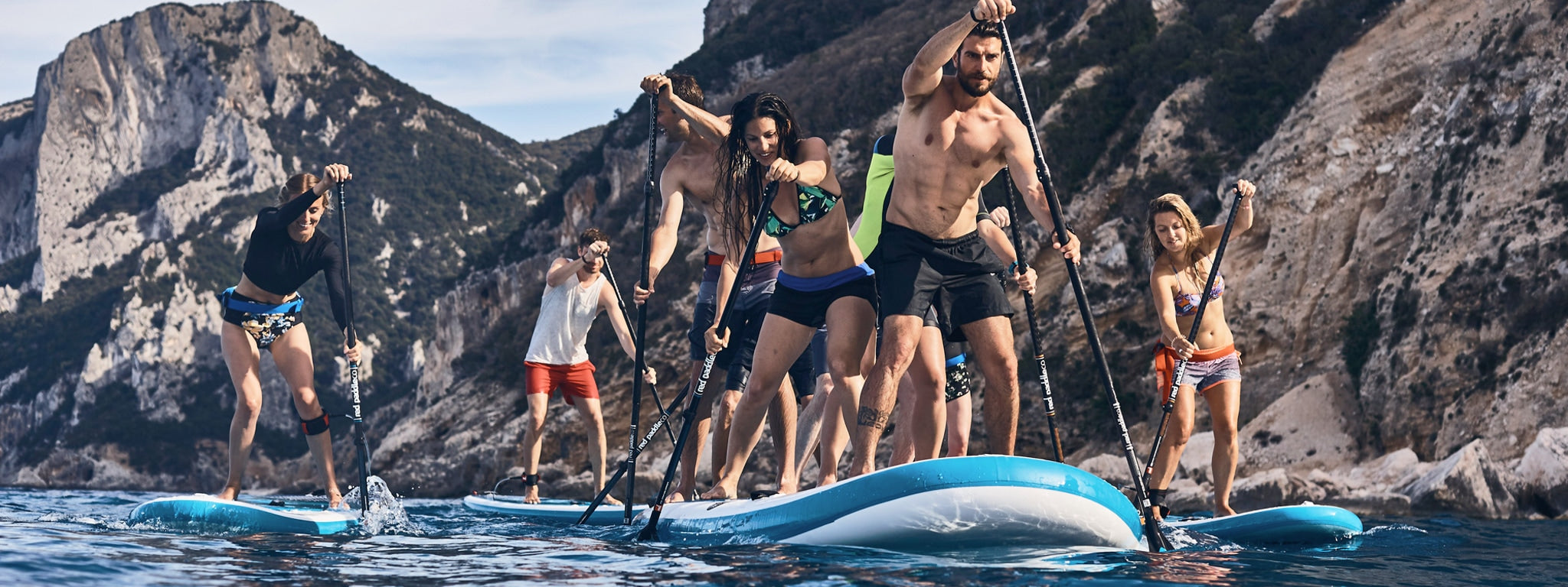 Multiple people paddling inflatable SUP paddle boards
