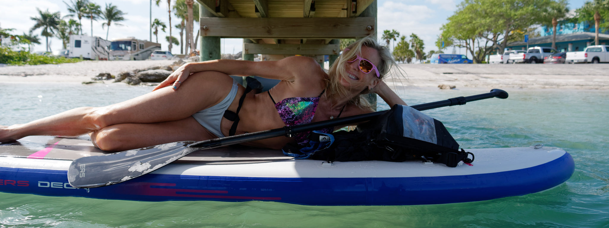 Paddler carrying SUP board in the sun